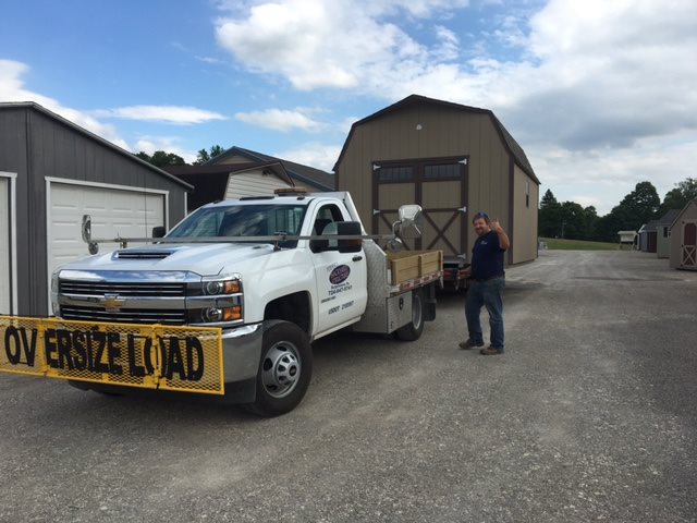 Picture of the owner posing with a shed on his truck, ready to go out for an install